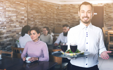 Waiter welcoming guests in restaurant