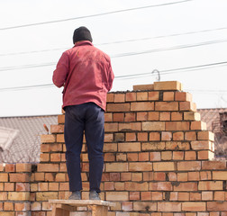 Worker builds a brick wall in the house