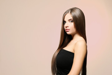 Fototapeta premium Young woman with healthy hair on light background