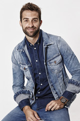 Fototapeta premium Man wearing denim jacket and shirt, smiling