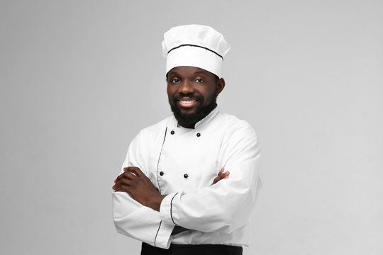African American chef in uniform on light background