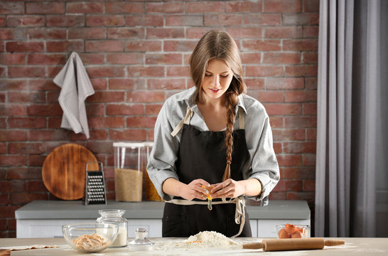 Woman preparing pasta on kitchen table