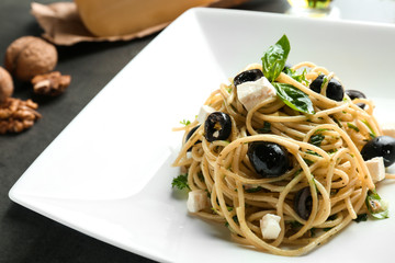 Plate with delicious pasta on gray table