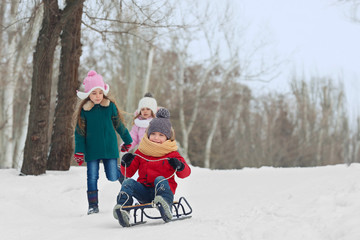 Fototapeta na wymiar Happy children having fun and sledding on snow