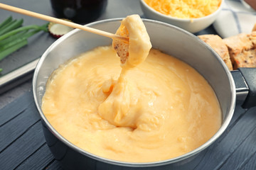 Dipping stick with bread in beer cheese dip