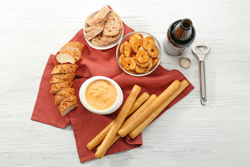 Bowl with beer cheese dip and snacks on wooden table