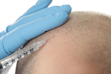 Man receiving stimulating injection for hair growth, closeup