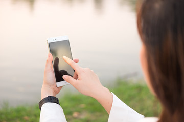 hand of woman holdiing the telephone in river background