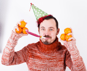 Man on holiday in hat and whistle with tangerines