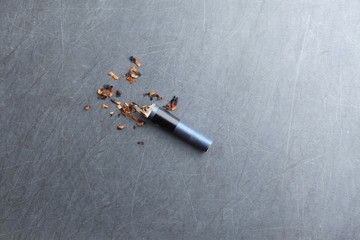 The cigarette ash and butt represent the cigarette and tobacco concept related idea.  