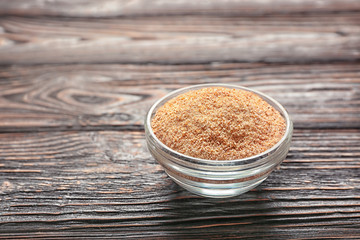 Glass bowl with bread crumbs on wooden table
