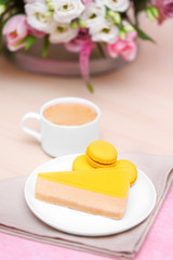 Cup of coffee, tasty cake and beautiful bouquet of flowers in cafe