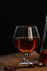 glass, carafe with cognac, whiskey and key on wooden table