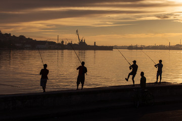 Fisher men fishing on sunrise in Havana, Cuba