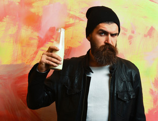Bearded brutal caucasian hipster holding glass jar of milk