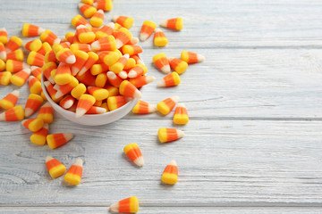 Colorful Halloween candy corns on wooden background