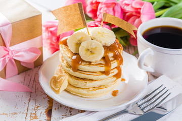 Mother's day breakfast concept - pancakes, coffee, flowers, present
