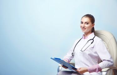 Young female nutritionist on light color background