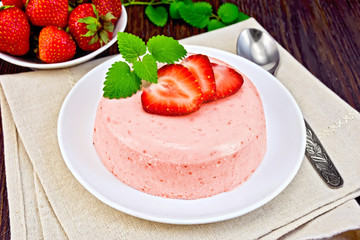 Panna cotta strawberry with mint on dark board