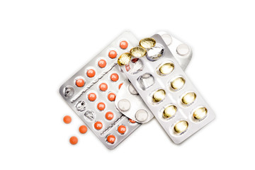 Red pills and capsules of cod-liver oil in blisters