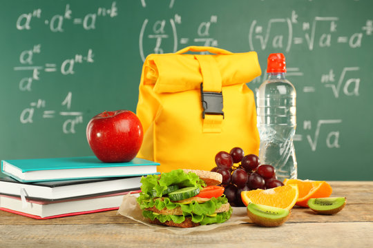 Lunch Bag On Wooden Table Against Chalkboard Background