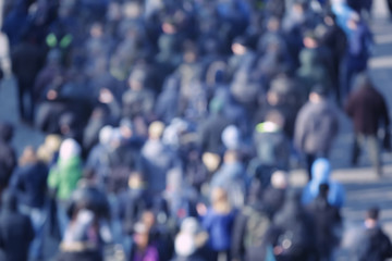 Crowd of people walking on busy city street, blurred view