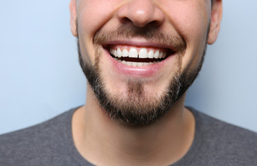 Smiling young man on color background, closeup