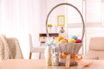 Fototapeta na wymiar Beautiful Easter basket with traditional treats on light table
