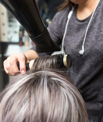 Styling female hair dryer in the beauty salon