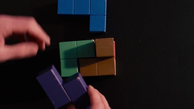 Man's hand picking 3D tetris