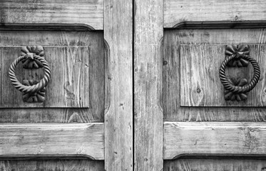 Details of an ancient Italian door, black and white.