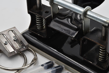 Concept for old office tools: hole puncher, ink for fountain pen and metal circle for paper. Macro
