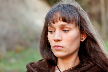 Sad brunette woman in the park