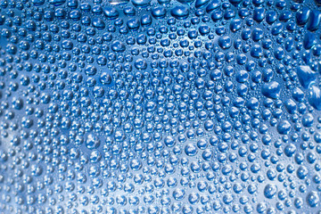 Blue surface with water drops. Focus on foreground, abstract texture and background