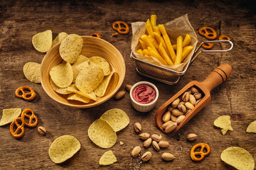 Fresh beer snacks. French fries, potato chips on wood background
