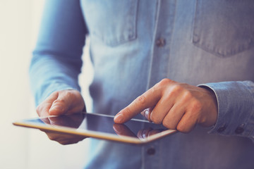 Man holding white digital tablet, view close up. Toned
