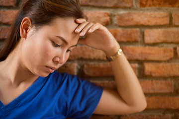 sad woman on the background of an old brick wall