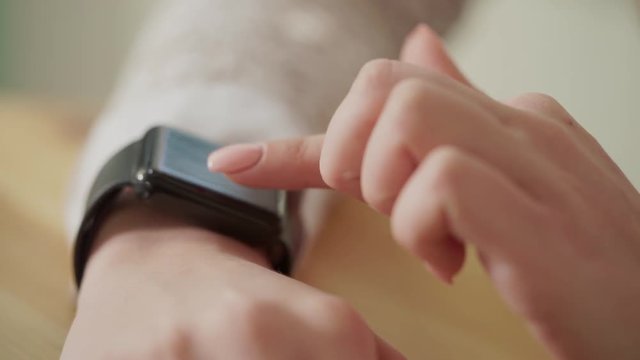 Macro shot of a young woman's fingers, who checks the news on a smart watch. This gadget helps to simplify the work, no one do not need to take the phone in them hands all the time.