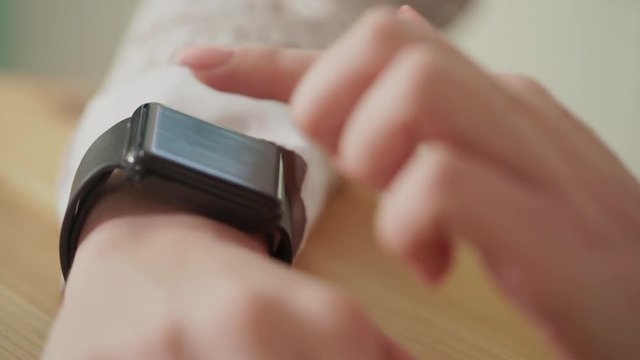 Macro shot of a young woman's fingers, who checks the news on a smart watch. This gadget helps to simplify the work, no one do not need to take the phone in them hands all the time.