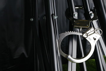 The chrome metal handcuffed bondage on the tripod black color represent the crime abstract concept related idea.