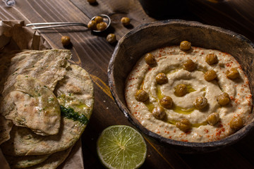 Homemade Chickpea Hummus in Rustic Bowl with Olive Oil and Fresh Pita Bread