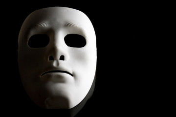 White human face mask on black background.