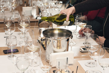 sommelier pouring wine into glass at wine tasting