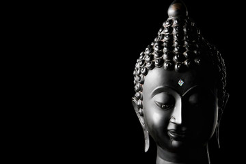 Buddha statue on black background. Free space for text
