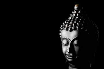 Buddha statue on black background. Free space for text