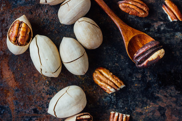 Pecan nut and wooden spoon on rustic table.