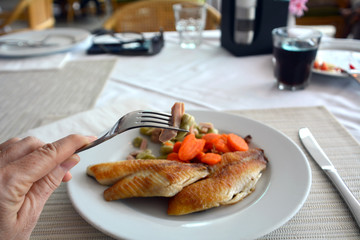 Grilled fish fillet with soybeans and ham on a white plate.,