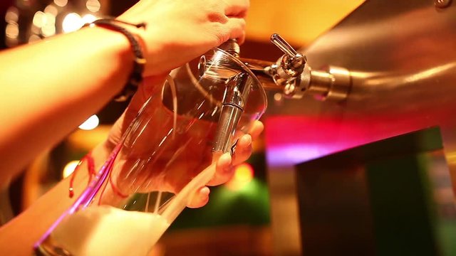 Color footage of a waiter pouring draught beer into a glass, in a pub or restaurant. 