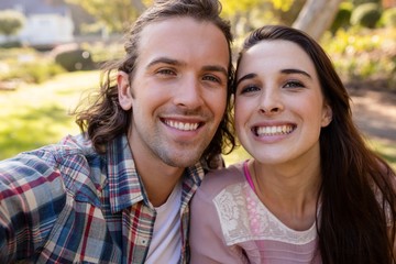 Fototapeta premium Young couple smiling in park