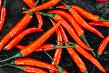 Red hot chili peppers over rustic surface - fresh and organic.